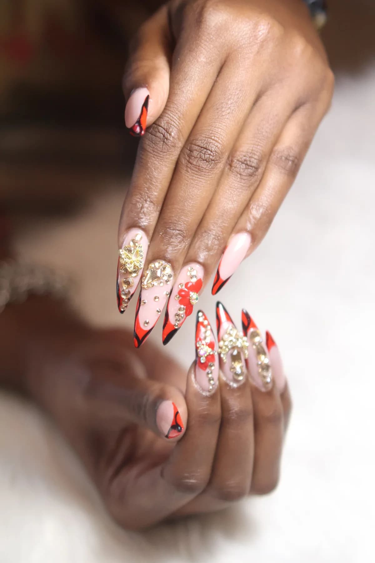 Close-up of pink, red and black nail art with gold details, for design inspiration