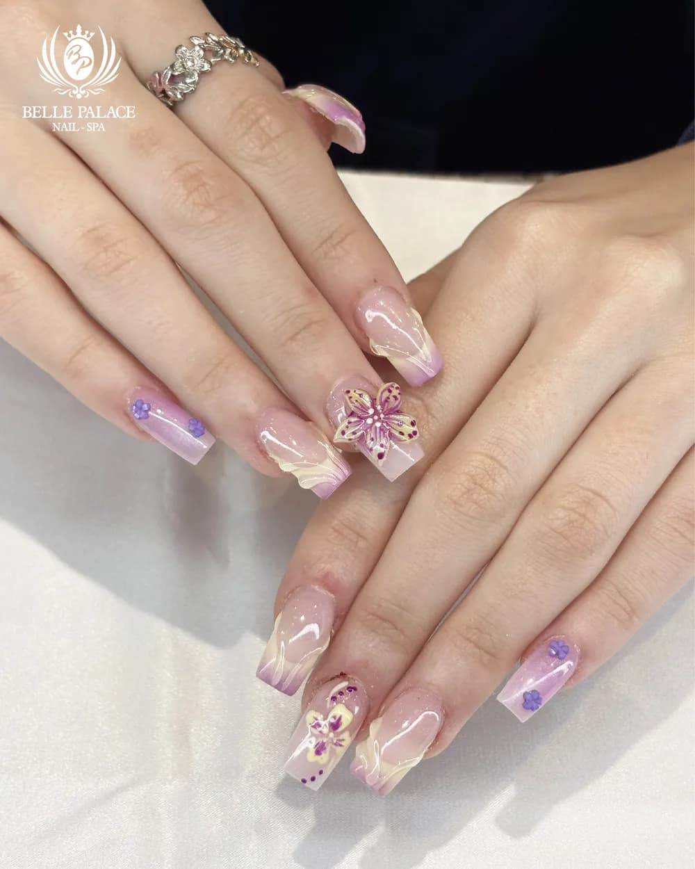 Pink and purple nails with 3D flower designs by Belle Palace Nail Spa